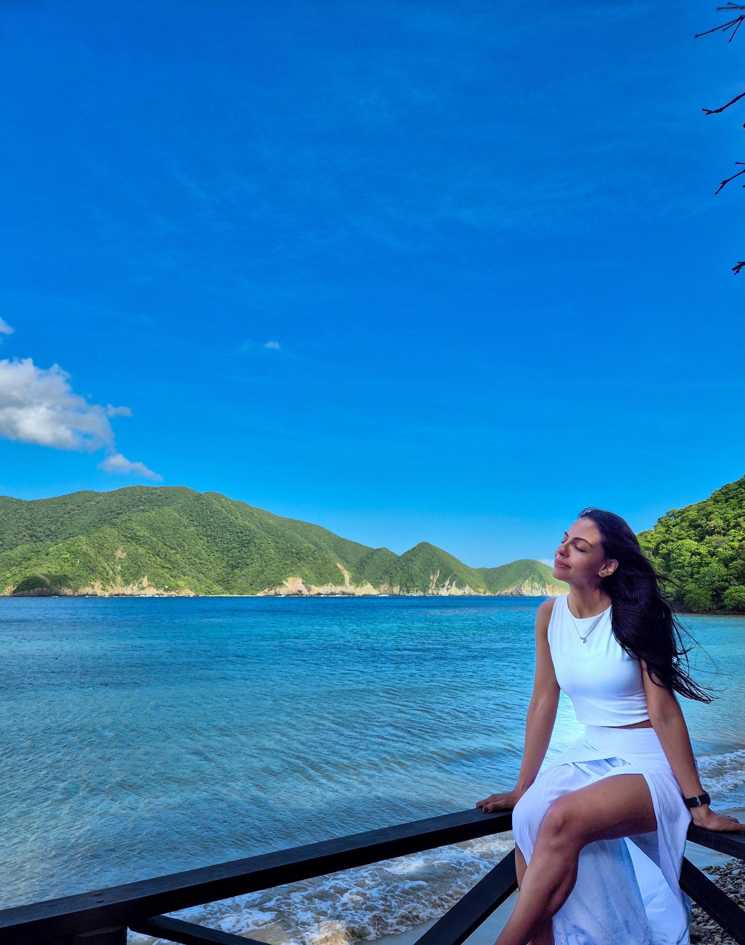 Alejandra Cárdenas frente al mar, vestida de blanco